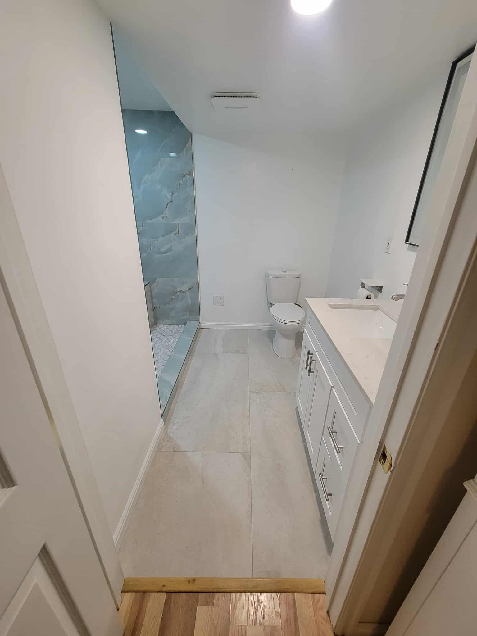 Luxury bathroom from doorway showing blue marble shower wall and white vanity